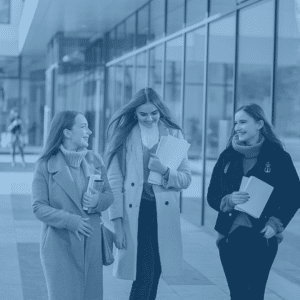 Three female college students walking on campus during their hybrid learning experience.