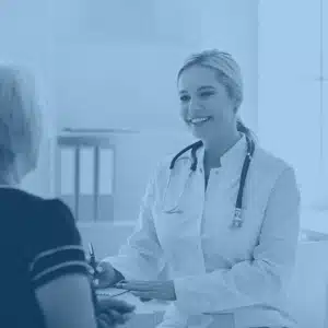 Female doctor speaking to a patient within a healthcare setting.