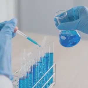 Pharmaceutical employee working in a lab with beakers and test tubes.